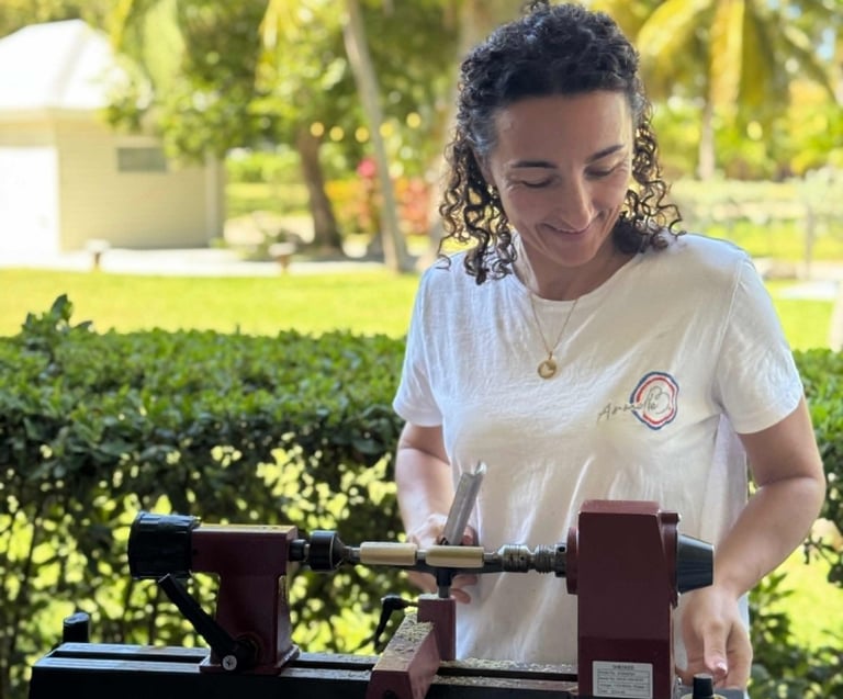 Armelle B. travaillant le bois sur son tour dans son atelier de création artisanale à Saint-Martin