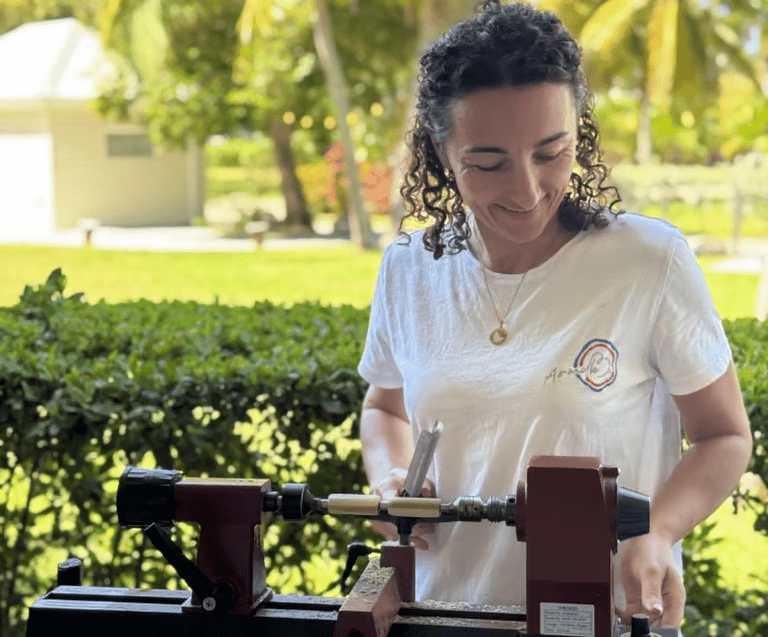 Armelle B. travaillant le bois sur son tour dans son atelier de création artisanale à Saint-Martin