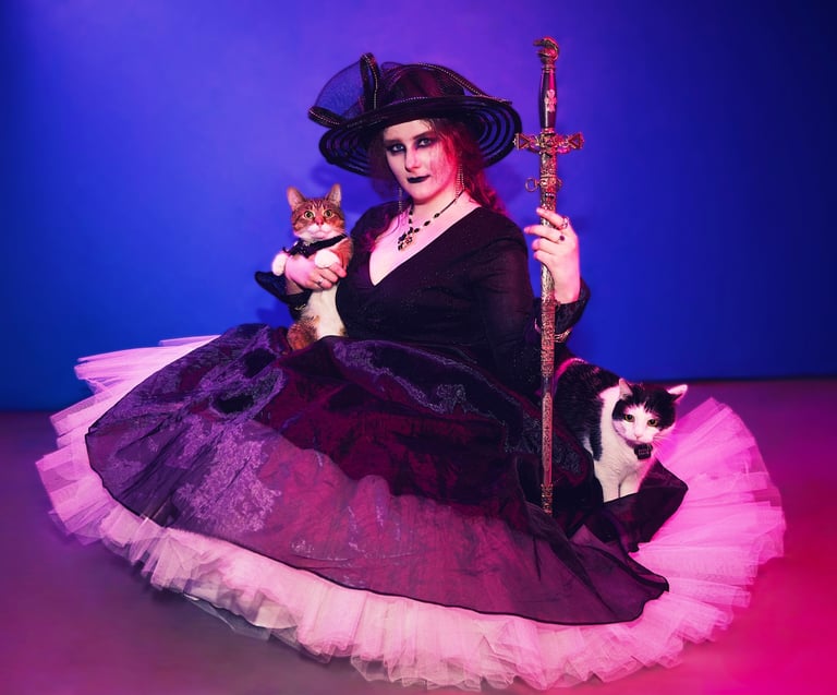 a woman in a witch costume holding a cat and a sword