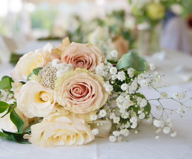 a bouquet of flowers on a table in a wedding reception