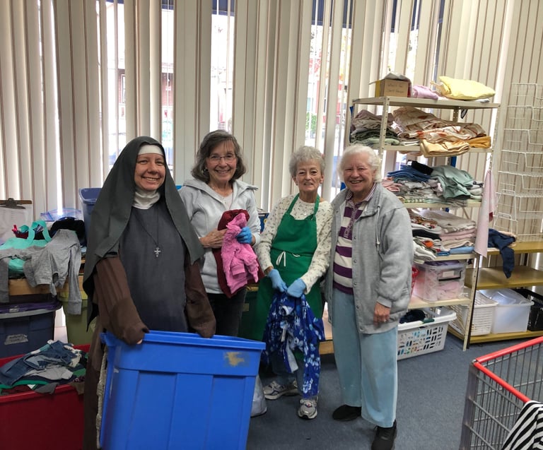 Rose Garden Volunteers sorting children's clothing. 