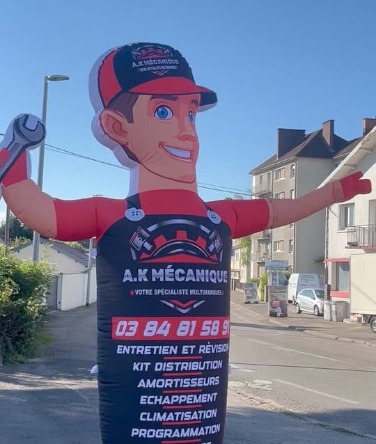 a man in a red and black suit and a large inflatable sign