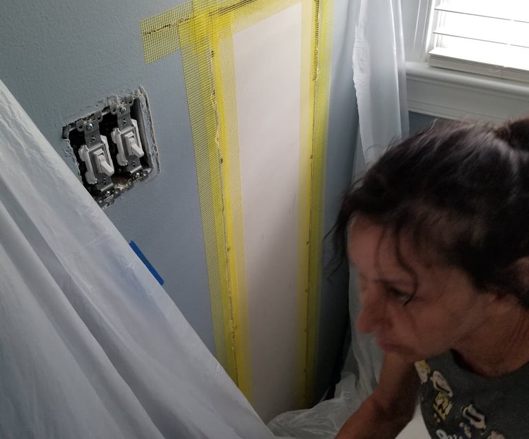 A picture of Janet Graybill doing a wall repair.