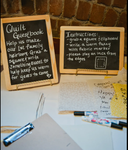Wedding guests signing fabric squares for a signature quilt guest book
