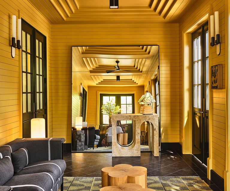 Kelly Wearstler design a hallway with a couch and a table.