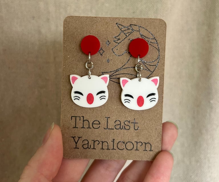 a card display of two Moogle acrylic earrings