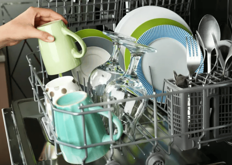 Plates, cups and glasses inside a dishwasher basket