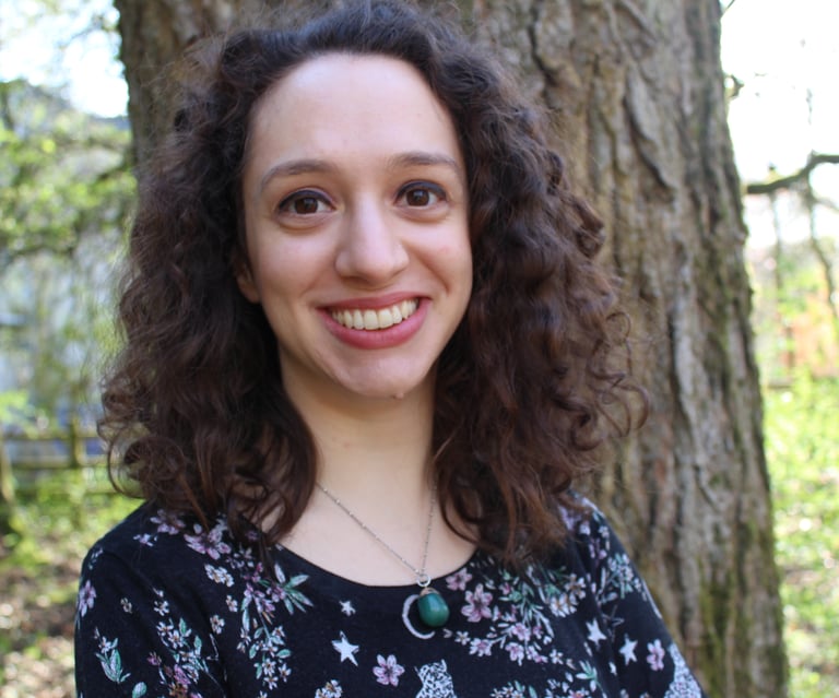 Headshot of Anna with a natural landscape background.