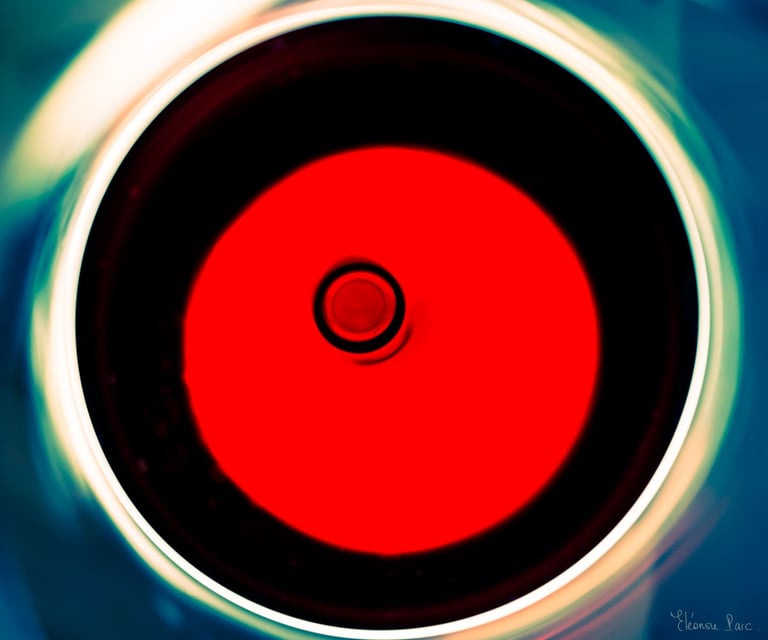 Abstraction Vinicole – Verre de vin vu du dessus, disque rouge et anneaux lumineux