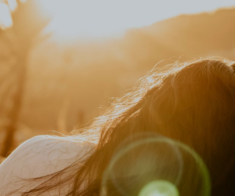 woman lying in nature with soft sunshine eliciting feelings of emotional balance