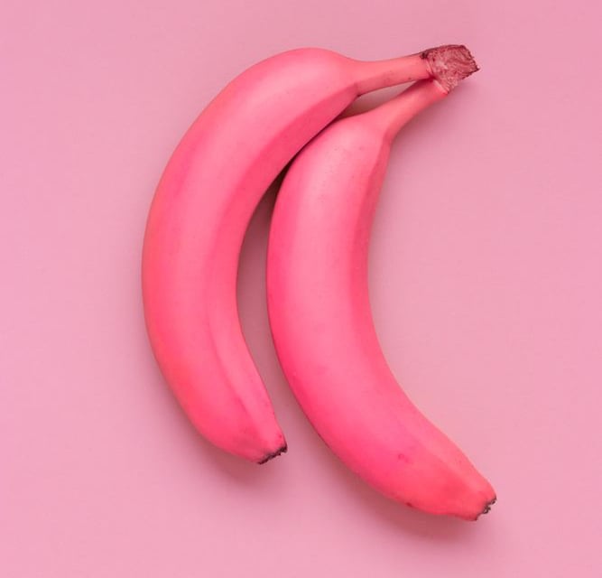 two bananas are shown on a pink background