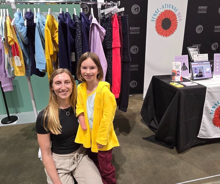Image of young girl and woman in front of rack of clothing