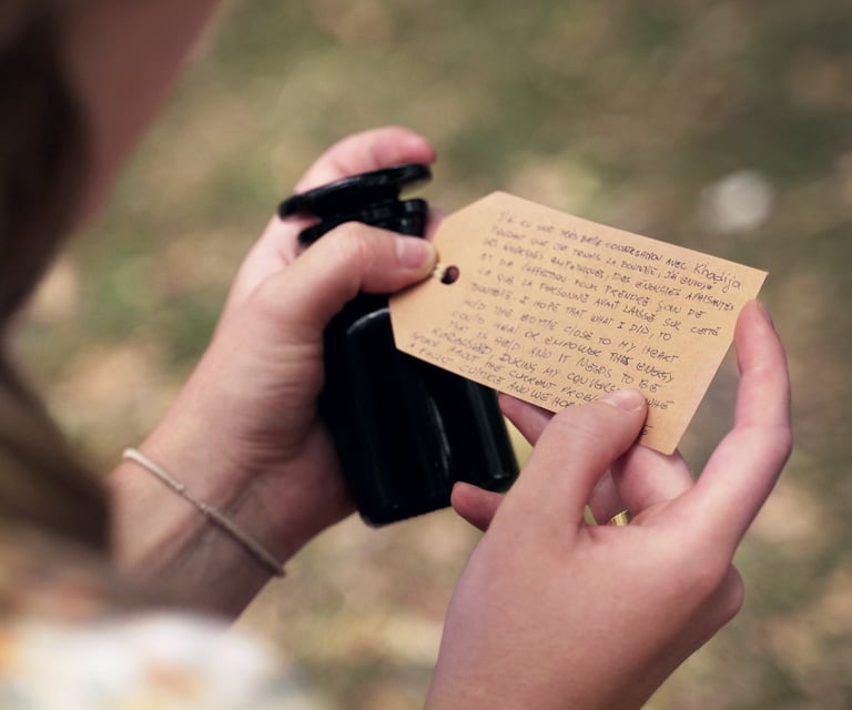 A woman holds an apothecary bottle with a handwritten note on the lid