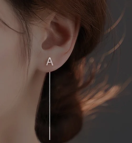 a woman wearing a pair of earrings with a long line of earrings