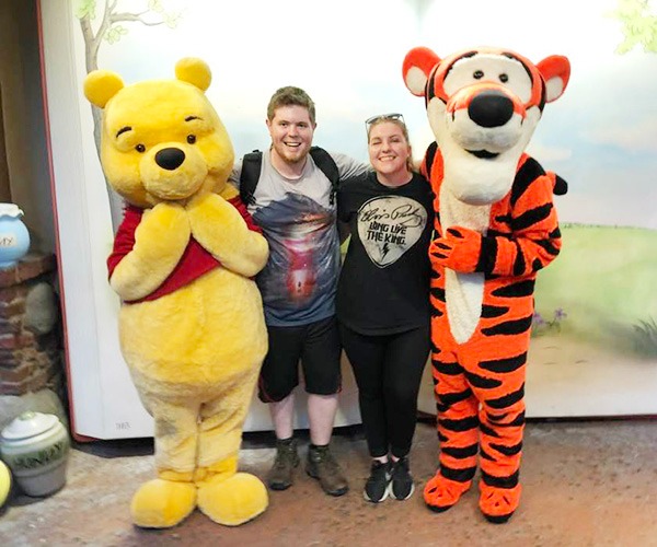 Sarah Brewer pictured with her husband, along with Winnie the Pooh and Tigger.
