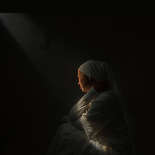 Mulher triste pensando nos problemas da vida, sem perceber a luz do céu sobre ela.