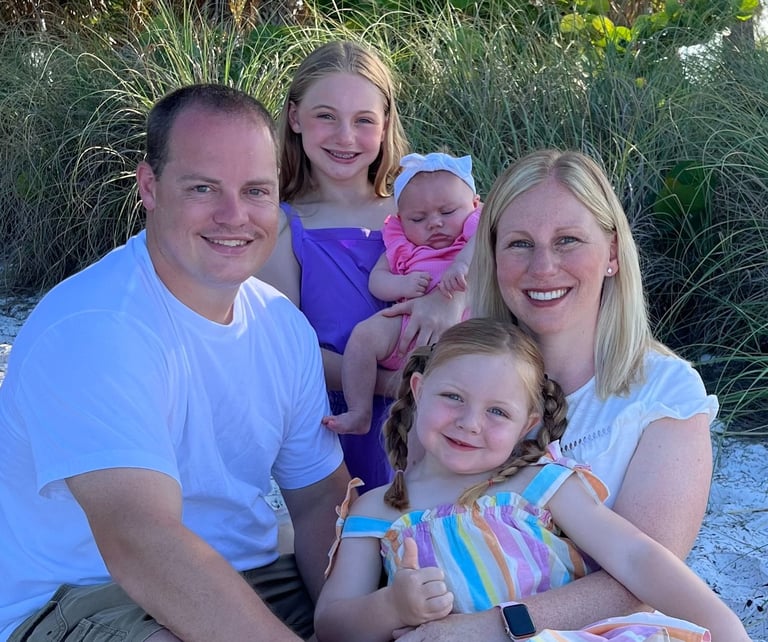 a family of four children sitting on a sandy beach