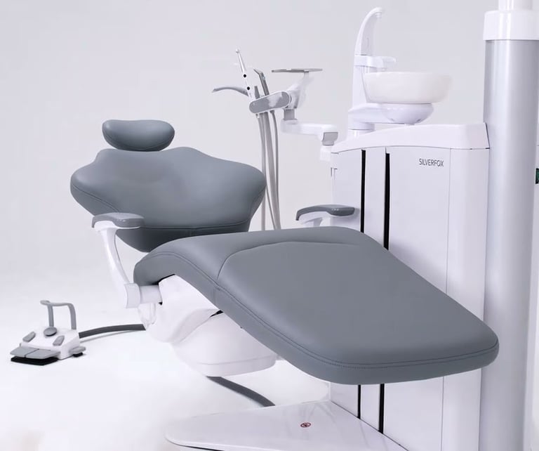 Modern ergonomic grey dental chair unit with professional tools in a clean clinic setting.
