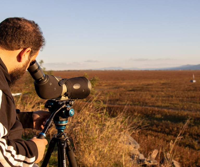 a man in a black jacket and a camera on a tripod