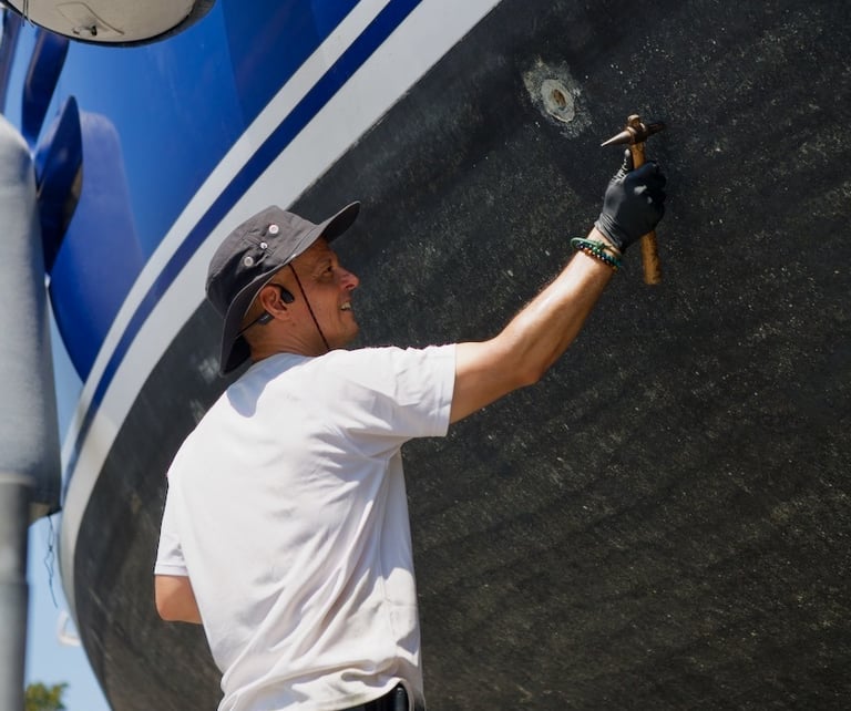our marine surveyor taking ulytrasonic measurements in a aluminium yacht