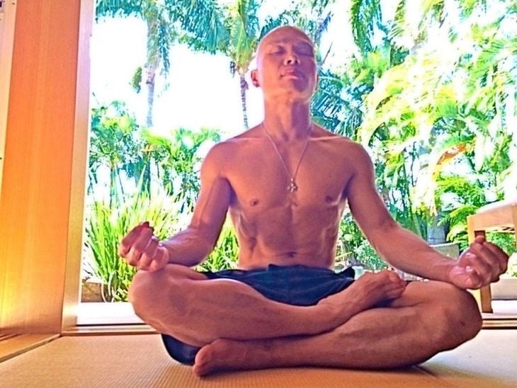 JEET KUNE DO BUDDHA sitting in a meditation position on a yoga mat.