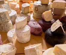 a table with cheese and cheeses and other foods