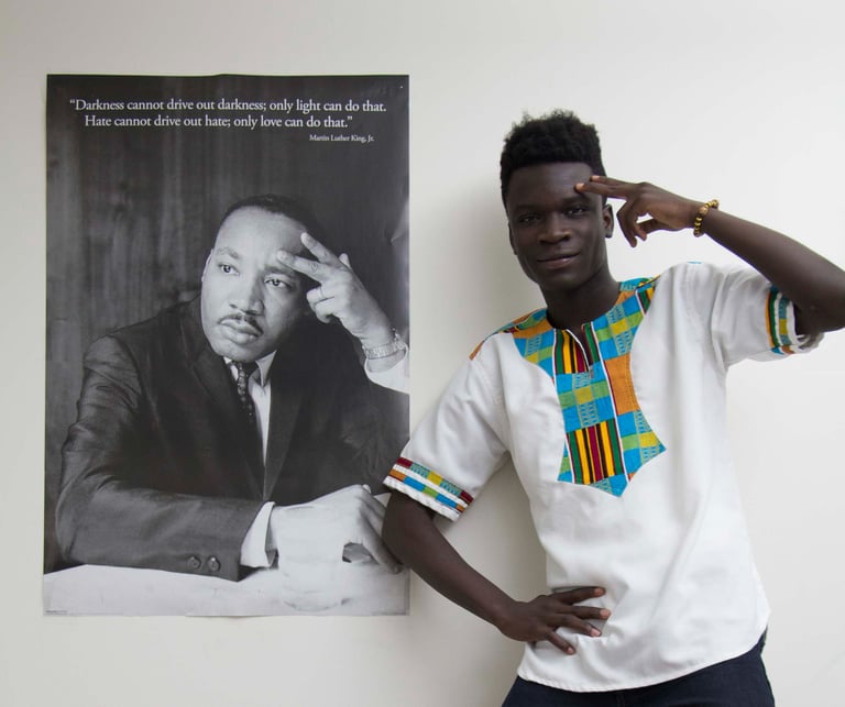 Photo of Martin Luter King's wall poster & a young boy in an original African garment posing. 