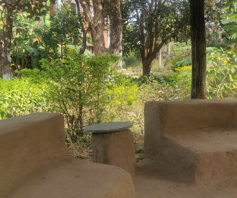 a bench with a table and chairs in a garden