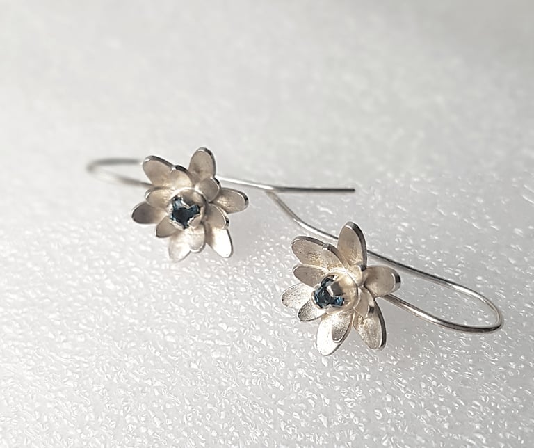 a pair of earrings with a flower design
