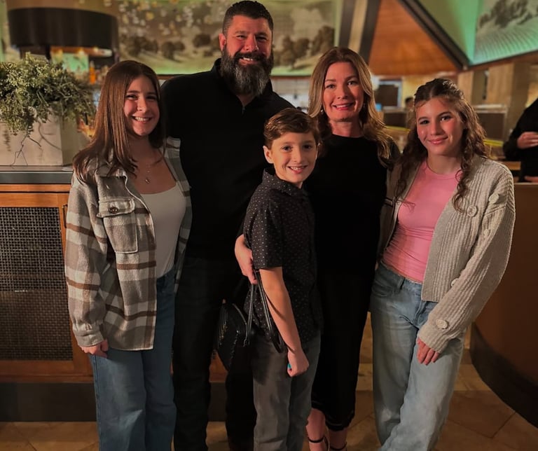 A family photo with 5 people in it. 3 children and two parents.