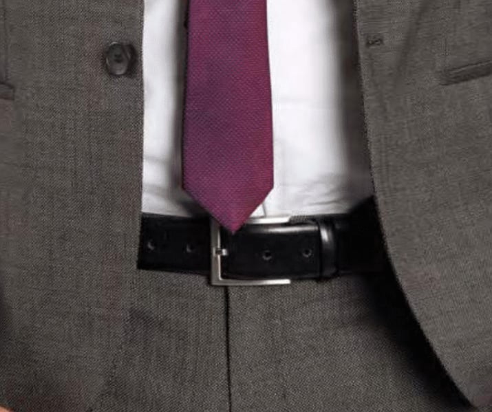 A close up of a monti belt on a man wearing a suit
