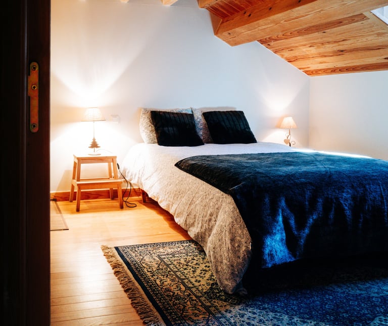 lit entouré de chevets avec coussins, plaid et tapis 
