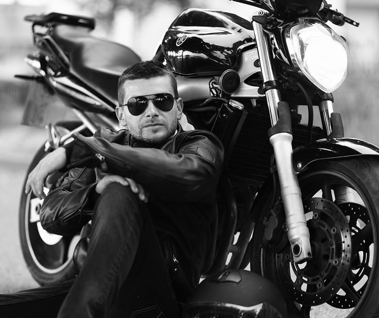 Audrius Turskas - a cool man sitting on the ground next to a motorcycle