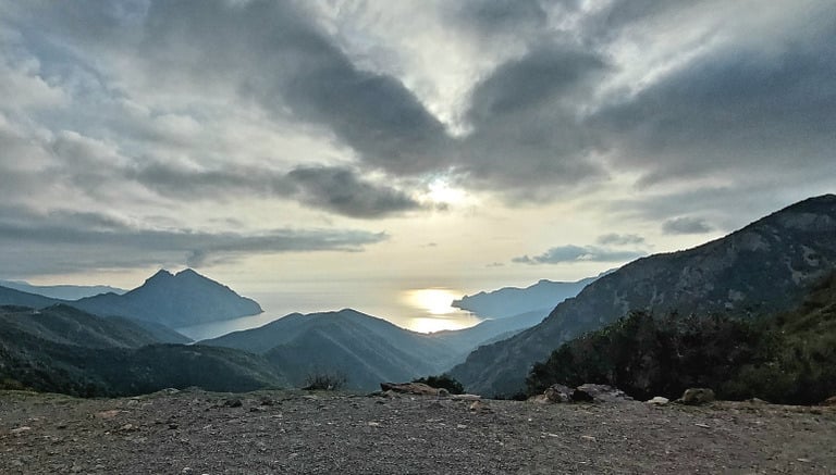 a person sitting on a bench in the mountains
