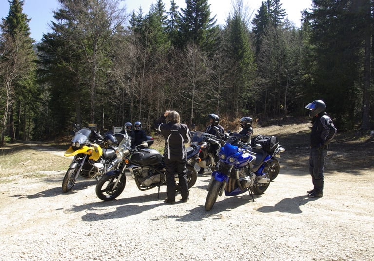 a group of people standing around a group of motorcycles