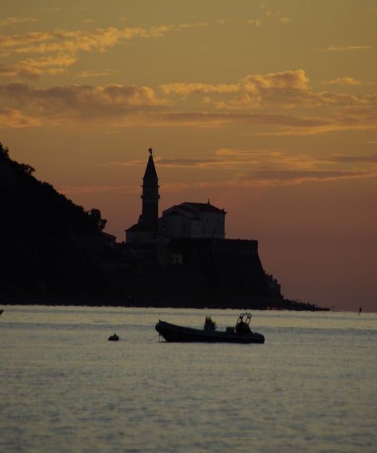 a boat in the water at sunset