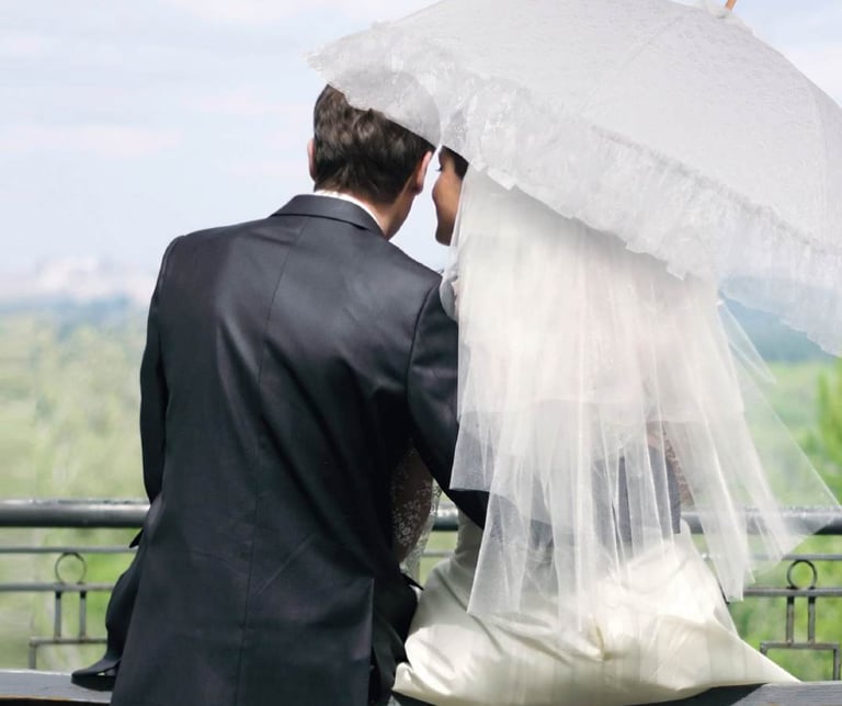 Married couple sitting together, the bride is holding an ornate doppler Manufaktur umbrella