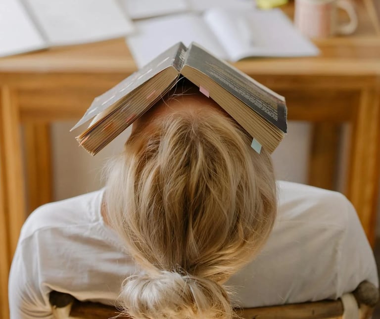 photo d'une jeune fille, un livre sur la tête, déconcentrée
