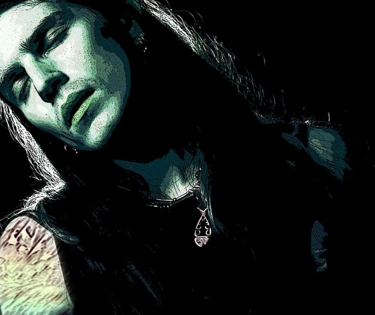 A handsome, long-haired, tattooed man in green and black hues