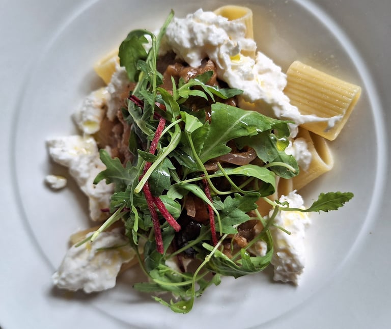 a plate of pasta with cheese and vegetables