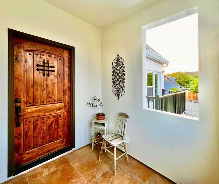 Welcoming entryway with a warm stained wood door and seating area.