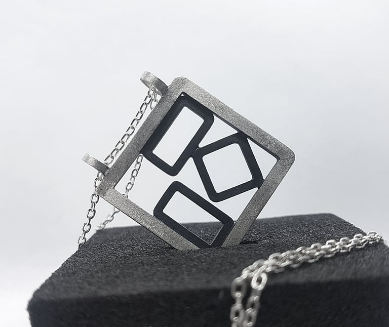 a square shaped pendant with a geometric design