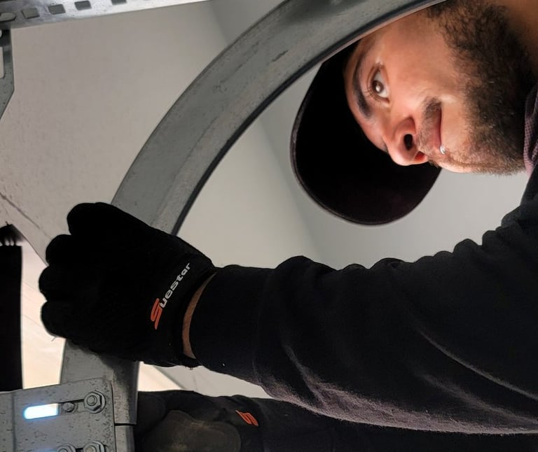 Alejandro Hernandez garage door technician performing maintenance on a garage door.