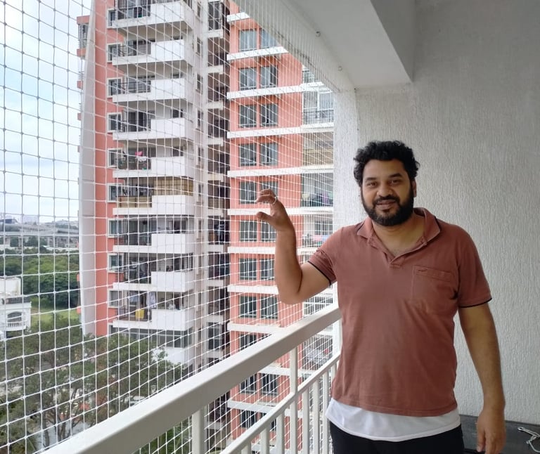 Smiling resident with newly installed pigeon nets in Indiranagar Bangalore