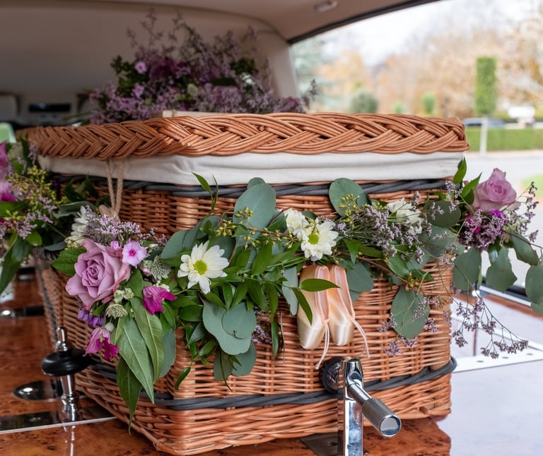 Wicker funeral casket decorated with fresh flowers