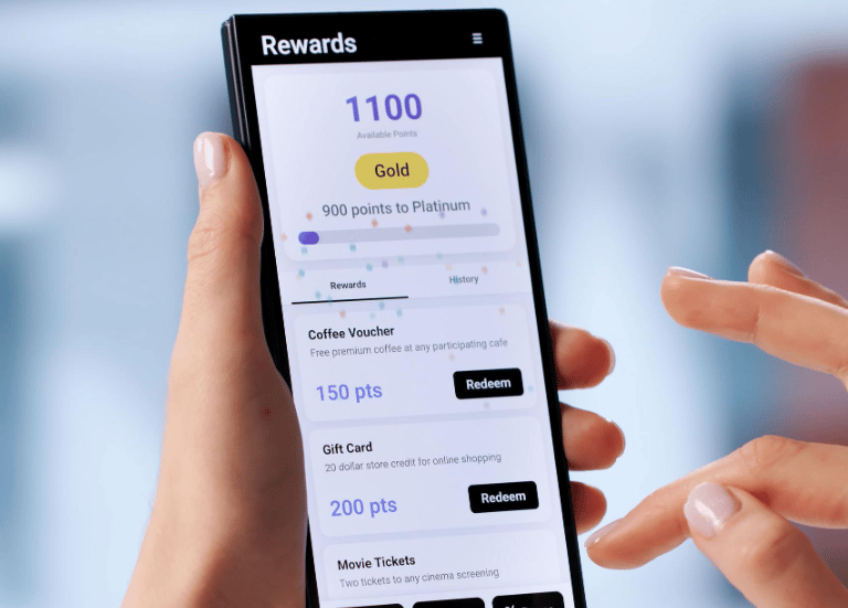 woman's hand holding phone and reviewing current points status of a loyalty and rewards program
