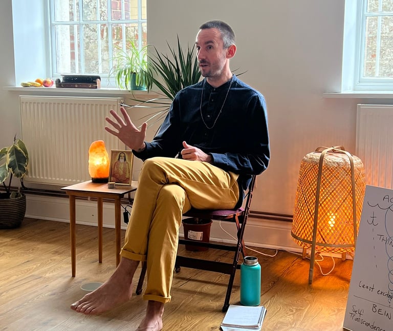 a male meditation teacher sitting in a chair