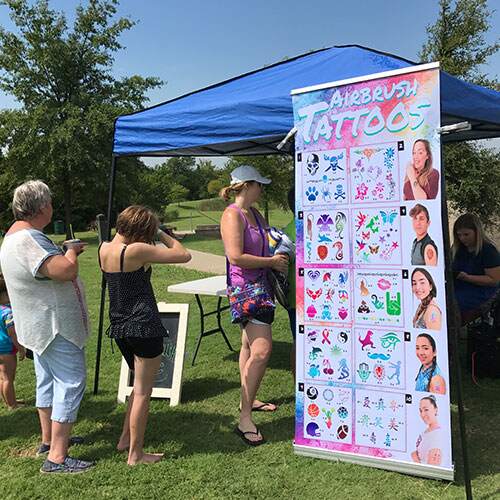 a group of people standing around a table with a sign
