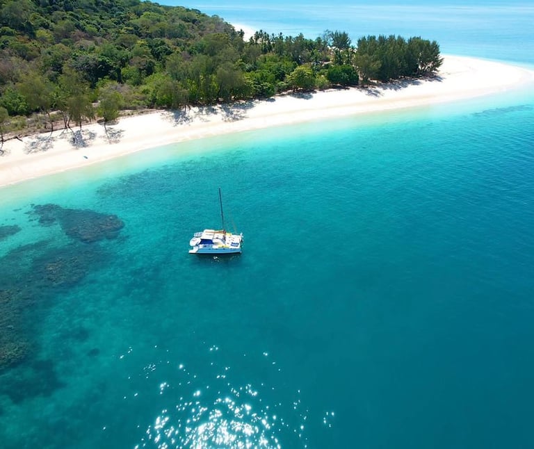 a boat in the water near a sandy beach nosy kalakajora Nosy Be