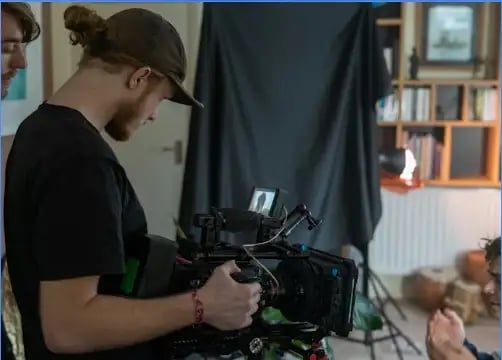 Behind-the-scenes indoor video production setup featuring a professional camera rig, studio lighting.